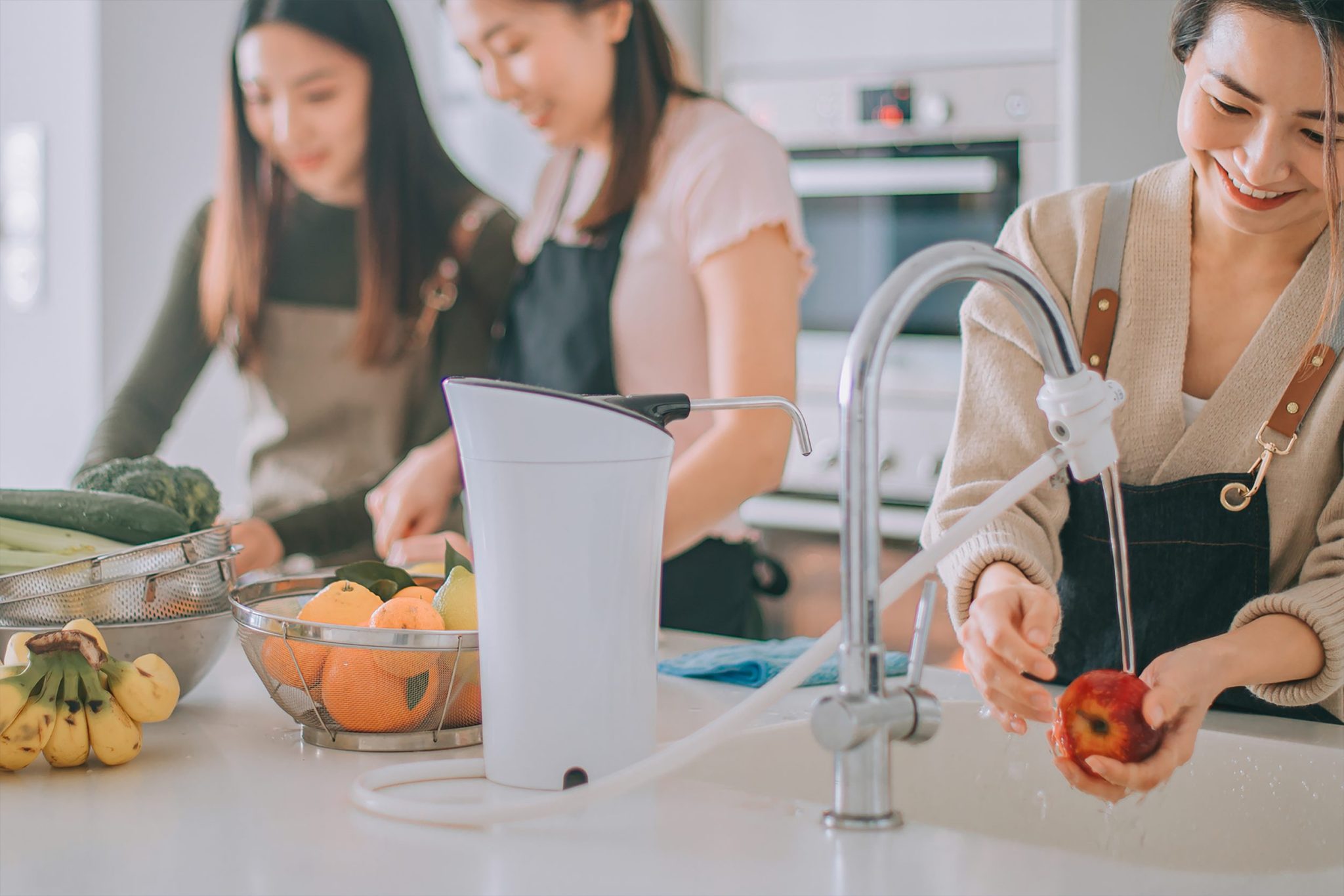 Three women preparing food together in a kitchen